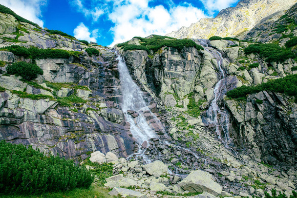 Panoramic view of Skok waterfall and the lake next to it in the western part of High Tatras, Slovakia - 写真・画像