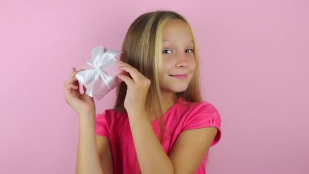 dívka s dárkem na barevném pozadí close-up - Záběry, video