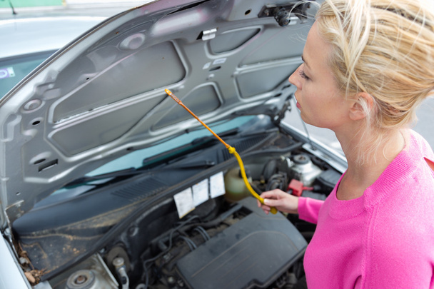 Woman inspecting broken car engine. - Photo, Image
