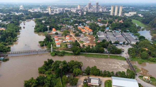 Las aguas de inundación alcanzan una casa y un campo de arroz en el centro de Tailandia en 2021. Muchos edificios están sumergidos en el agua. Foto desastre desde arriba vista por dron - Foto, imagen