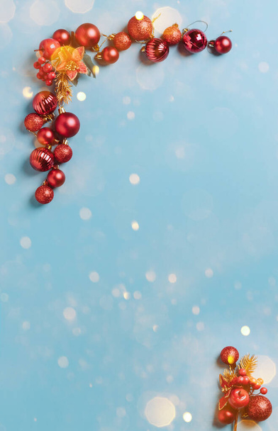 Adornos navideños bolas rojas de Año Nuevo forradas con un marco sobre un fondo azul con copos de nieve, destellos, confeti - Foto, imagen