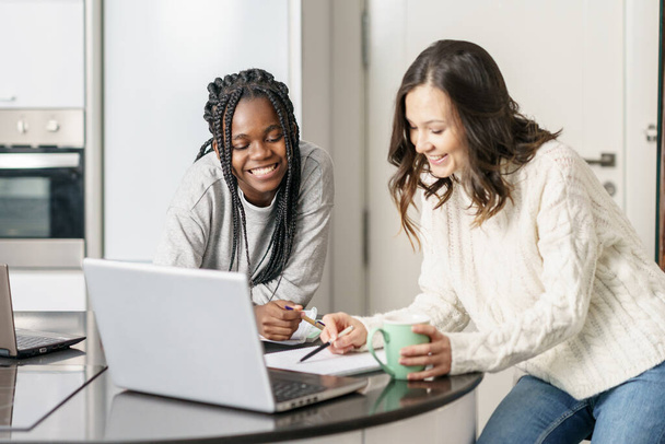 Zwei College-Mädchen lernen gemeinsam zu Hause mit Laptops beim Kaffeetrinken - Foto, Bild