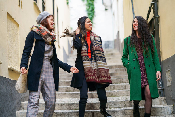 Multiethnische Gruppe von drei glücklichen Frauen, die zusammen im Freien gehen - Foto, Bild