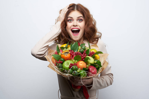 portrait of a woman fun posing fruit bouquet vitamins isolated background - Foto, afbeelding