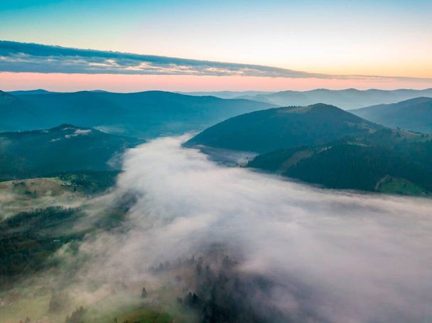 Nebel im Gebirgstal im Morgengrauen. Ukrainische Karpaten am Morgen im Dunst. Drohnenblick aus der Luft. - Foto, Bild