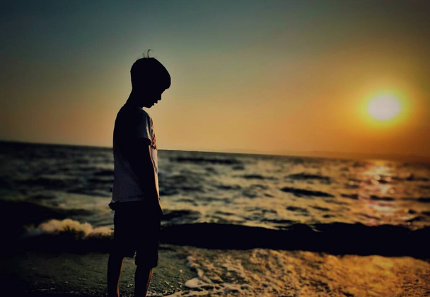 silhouette of a boy on the beach - Foto, afbeelding
