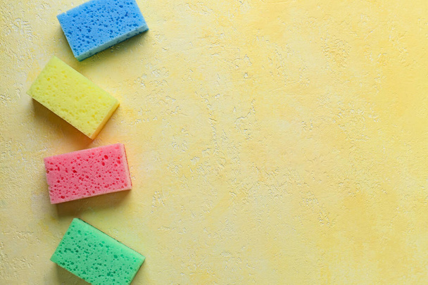 Different cleaning sponges on color background - Fotografie, Obrázek