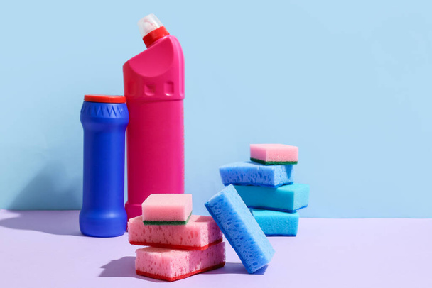 Limpar esponjas e garrafas de detergente sobre fundo de cor - Foto, Imagem