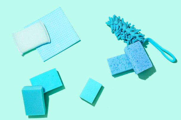 Diferentes esponjas de limpieza y trapo sobre fondo de color - Foto, imagen