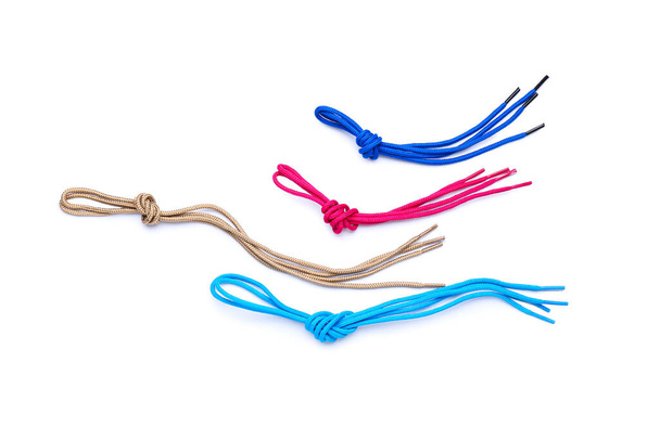 Different shoe laces tied in knots on white background - Foto, afbeelding