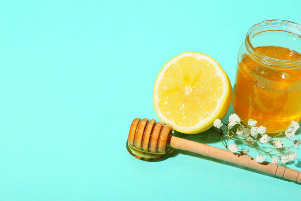 Pot de miel doux, trempette et citron sur fond de couleur - Photo, image