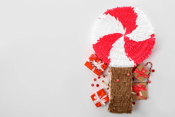 Pinata piruleta con caramelos y regalos sobre fondo blanco - Foto, Imagen
