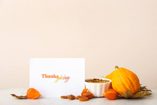 Tasty pumpkins, pie and text THANKSGIVING on light table - Photo, Image