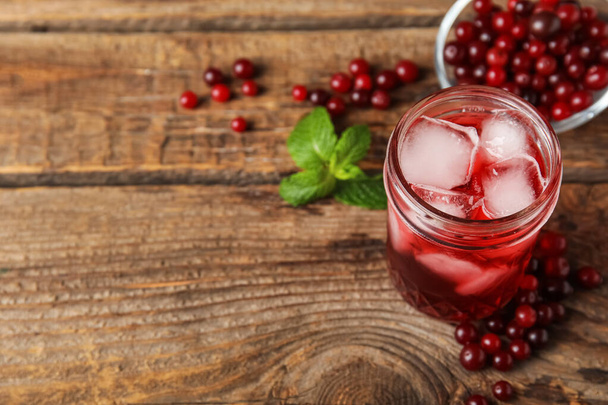 Glass with healthy cranberry juice on wooden background - Foto, imagen