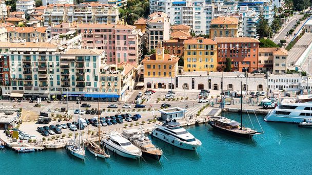 View of the sea port in Nice, France. Moored boats and yachts, buildings and greenery, blue water of the Mediterranean sea - Foto, afbeelding