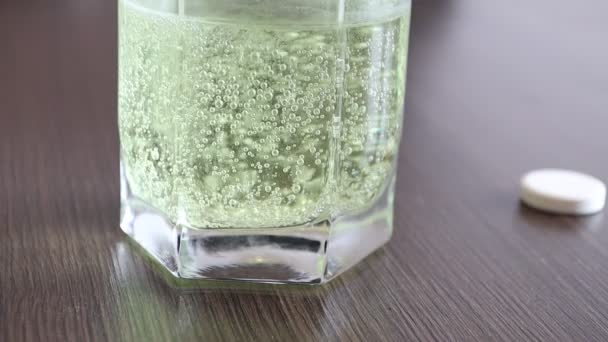 Aspirin or effervescent pill tablet sparkling bubbles in glass of water - Footage, Video
