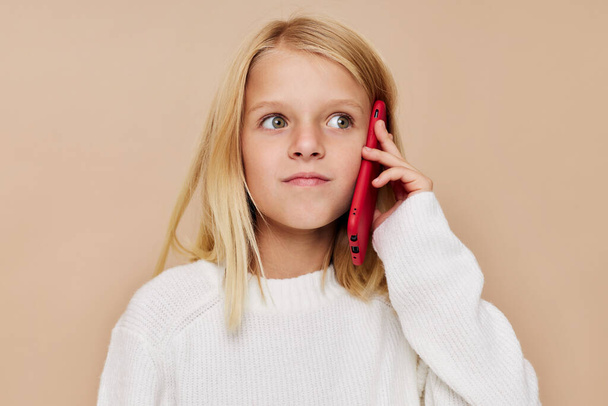 boldog aranyos lány beszél a telefon technológia pózol stúdió - Fotó, kép