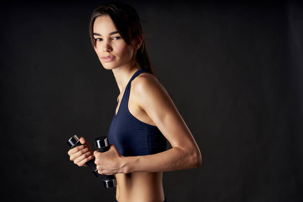 спортивная женщина с гантелями в руке с тренировочными упражнениями студийный тренажерный зал - Фото, изображение