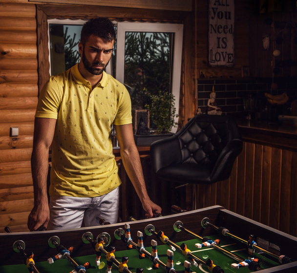 Young handsome man in yellow t-shirt playing on soccer. - 写真・画像