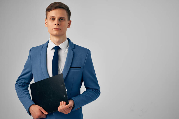 man in a suit with documents in his hands professional office light background - Fotoğraf, Görsel