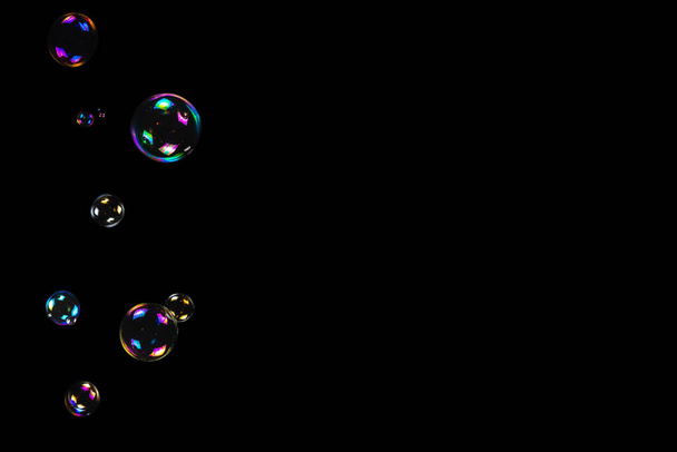 Мильні бульбашки ізольовані на чорному тлі. Копіювати простір
.  - Фото, зображення