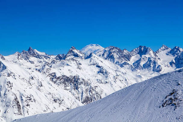 Montagnes du Caucase, vue panoramique sur la piste de ski avec les montagnes Belalakaya, Sofrudzhu et Sulakhat à l'horizon dans la journée d'hiver. Station de ski Dombai, Caucase occidental, Karachai-Tcherkess, Russie. - Photo, image
