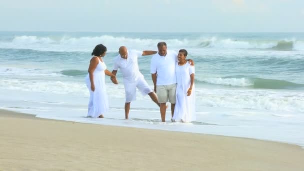 ältere afrikanisch-amerikanische Freunde zu Fuß am Strand - Filmmaterial, Video
