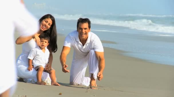 молодий латиноамериканського сім'ї грає піщаним пляжем - Кадри, відео