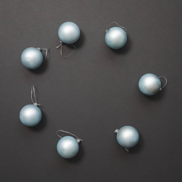 Світло-блакитні матові різдвяні кульки лежать в колі на темному тлі. Новорічний макет
 - Фото, зображення