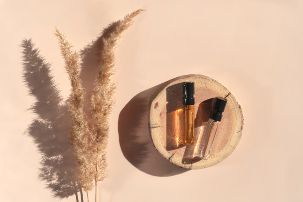 Kaksi parfyymi testaajat puinen tarjotin makaa beige tausta pampas ruoho - Valokuva, kuva