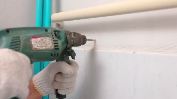 Työntekijä asentaa kelluva putki seinään vanhassa kylpyhuoneessa - Materiaali, video
