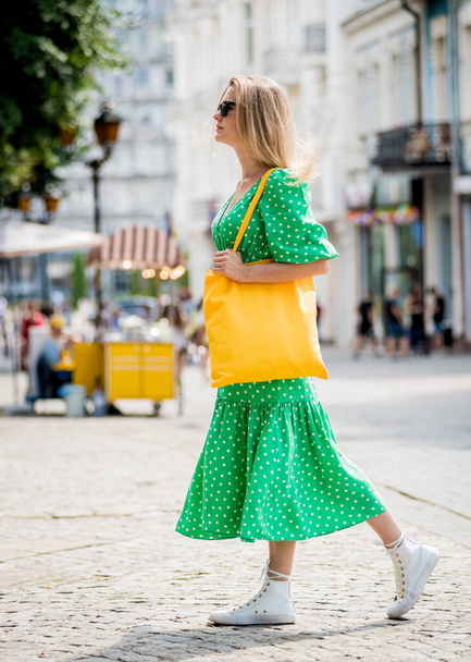 Young beautyful woman with yellow linen eco bag on city background. - Φωτογραφία, εικόνα