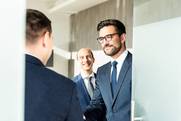 Group of cheerful confident business people greeting with a handshake at business meeting in modern office. - Fotoğraf, Görsel
