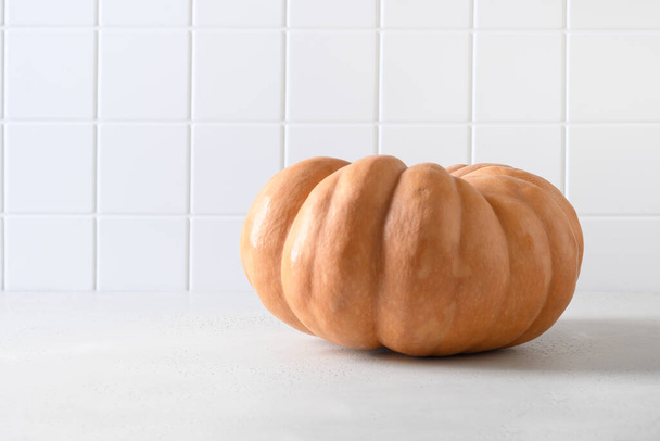 Organic big pumpkin on a white background with Halloween decorations. Autumn harvest for fest. - Фото, изображение