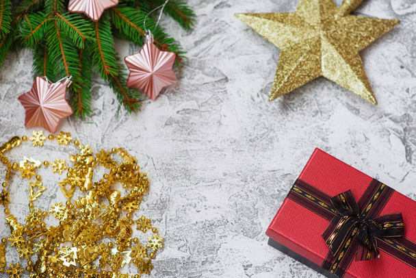 Silvestrovské nebo vánoční složení smrkových zelených větví, novoroční věnce, dárek, hvězda a vánoční hračky na jasném texturálním pozadí. Plocha, dispozice, kopírovací prostor - Fotografie, Obrázek
