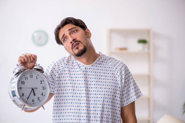 Young male patient in time management concept - Фото, изображение