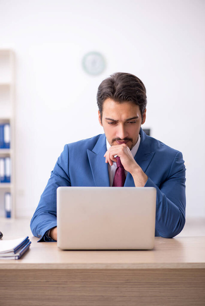 Giovane dipendente maschio infelice con un lavoro eccessivo in ufficio - Foto, immagini