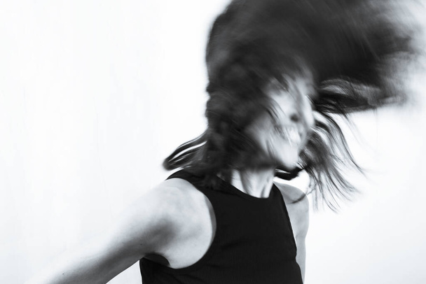 40 yaşından büyük bir kadının hareket bulanık portresi. Siyah tişört - Fotoğraf, Görsel