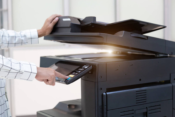 Bouton de presse d'homme d'affaires sur le panneau du réseau de photocopieur d'imprimante, travaillant sur des photocopies dans le concept de bureau, imprimante est équipement d'outil d'employé de bureau pour numériser et copier le papier. - Photo, image
