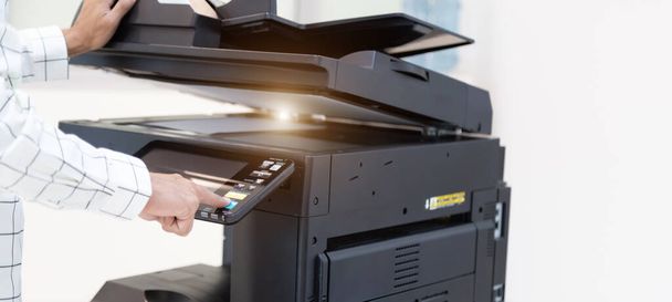 El hombre de negocios presiona el botón en el panel de la red de fotocopiadoras de la impresora, trabajando en fotocopias en el concepto de oficina, la impresora es el equipo de herramientas del trabajador de oficina para escanear y copiar papel. - Foto, imagen