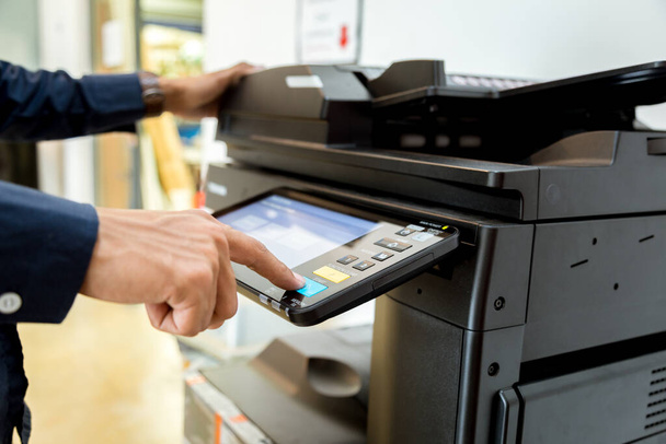 Bussiness man Hand press button on panel of printer, printer scanner laser office copy machine supplies start concept. - Zdjęcie, obraz