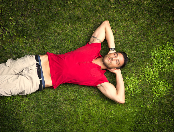 Fit male model lying on the grass - Φωτογραφία, εικόνα