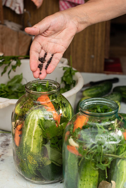 Preparation of canned cucumbers or fermented cucumbers in glass jars. Ingredients for pickling cucumbers. Cucumbers, dill, garlic. Glass jars with pickles. Processing of the autumn harvest.  - Photo, Image