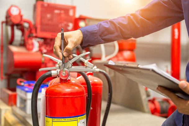 Engenheiro está verificando e inspeção de um tanque de extintores de incêndio na sala de controle de incêndio para treinamento de segurança e prevenção de incêndio. - Foto, Imagem
