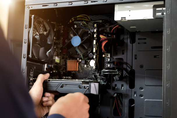 De technicus houdt de schroevendraaier voor het herstellen van de computer. het concept van computerhardware, reparatie, upgrade en technologie. - Foto, afbeelding