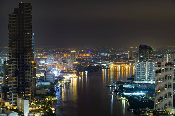 Вид на город Бангкок ночью вдоль реки Чао Прайя без логотипов и торговых марок - Фото, изображение