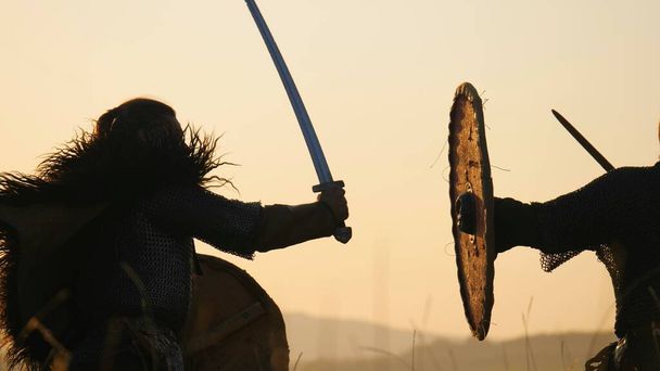 Sylwetki wojowników Viking są walki na miecze i tarcze. Contre jour - Zdjęcie, obraz