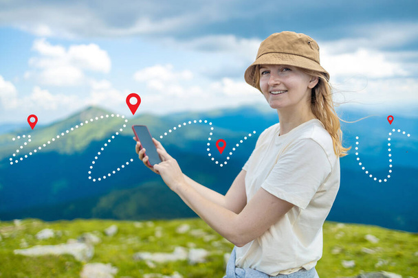 Success tourist woman searching right direction on smartphone on top of mountain with nature background. Mountain progression path. - Photo, Image