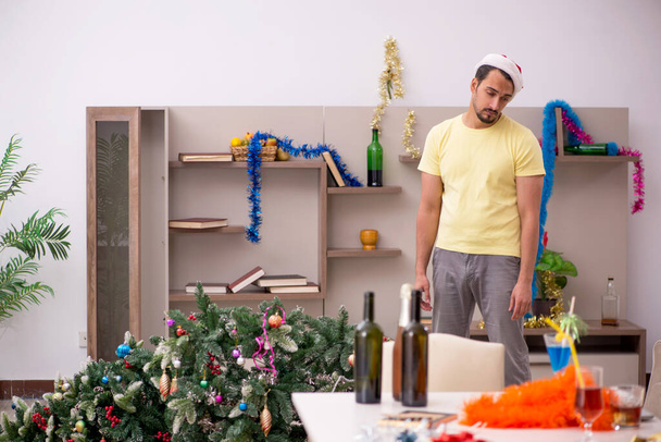 Nuori mies puhdistaa asunnon joulun jälkeen - Valokuva, kuva