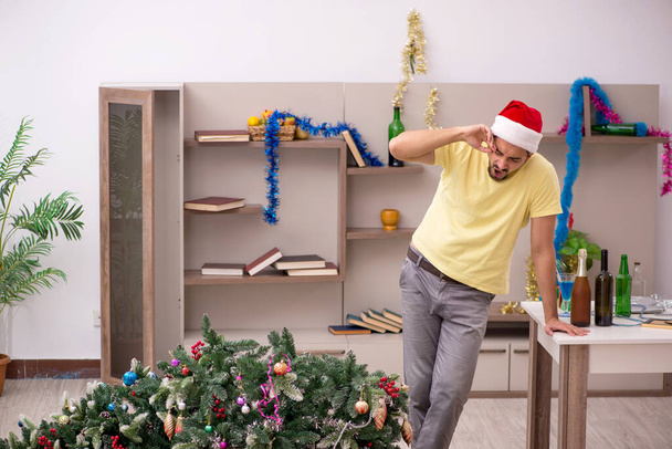 Young man cleaning the apartment after Christmas party - Photo, image